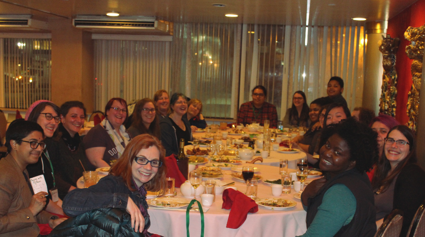 [ A photo of a group of individuals (women, non-binary, and other gender minorities) sitting at dinner. ]