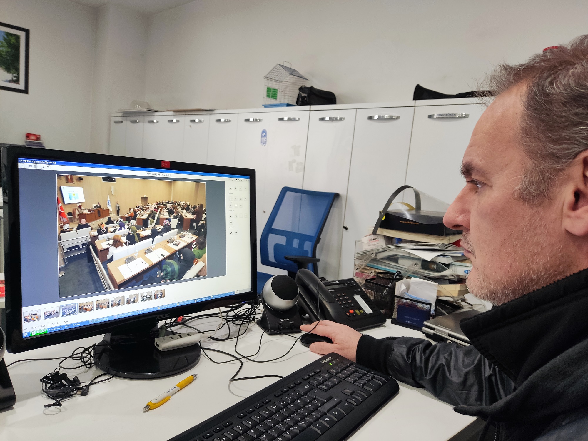 Municipal employee using Windows-themed Pardus Linux to manage photo portfolio