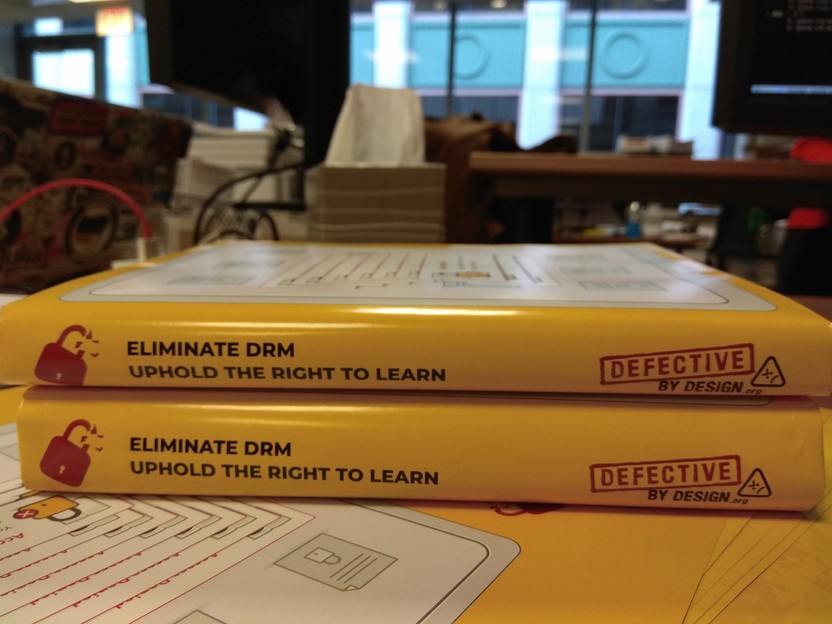 Photo of two books, both wrapped in a dust jacket that says "Eliminate DRM. Uphold the right to learn."