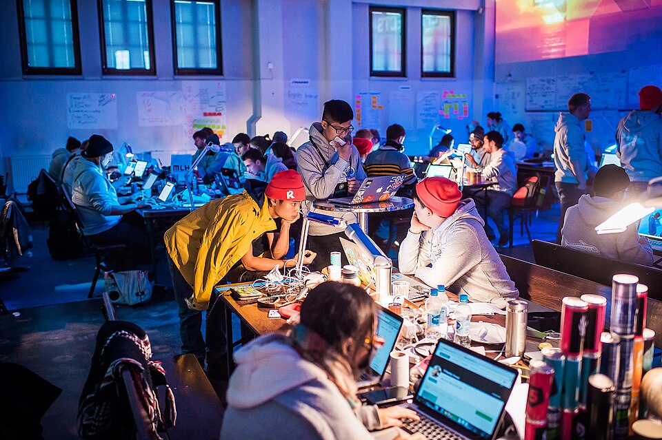 photo of people working on different projects at a hackathon