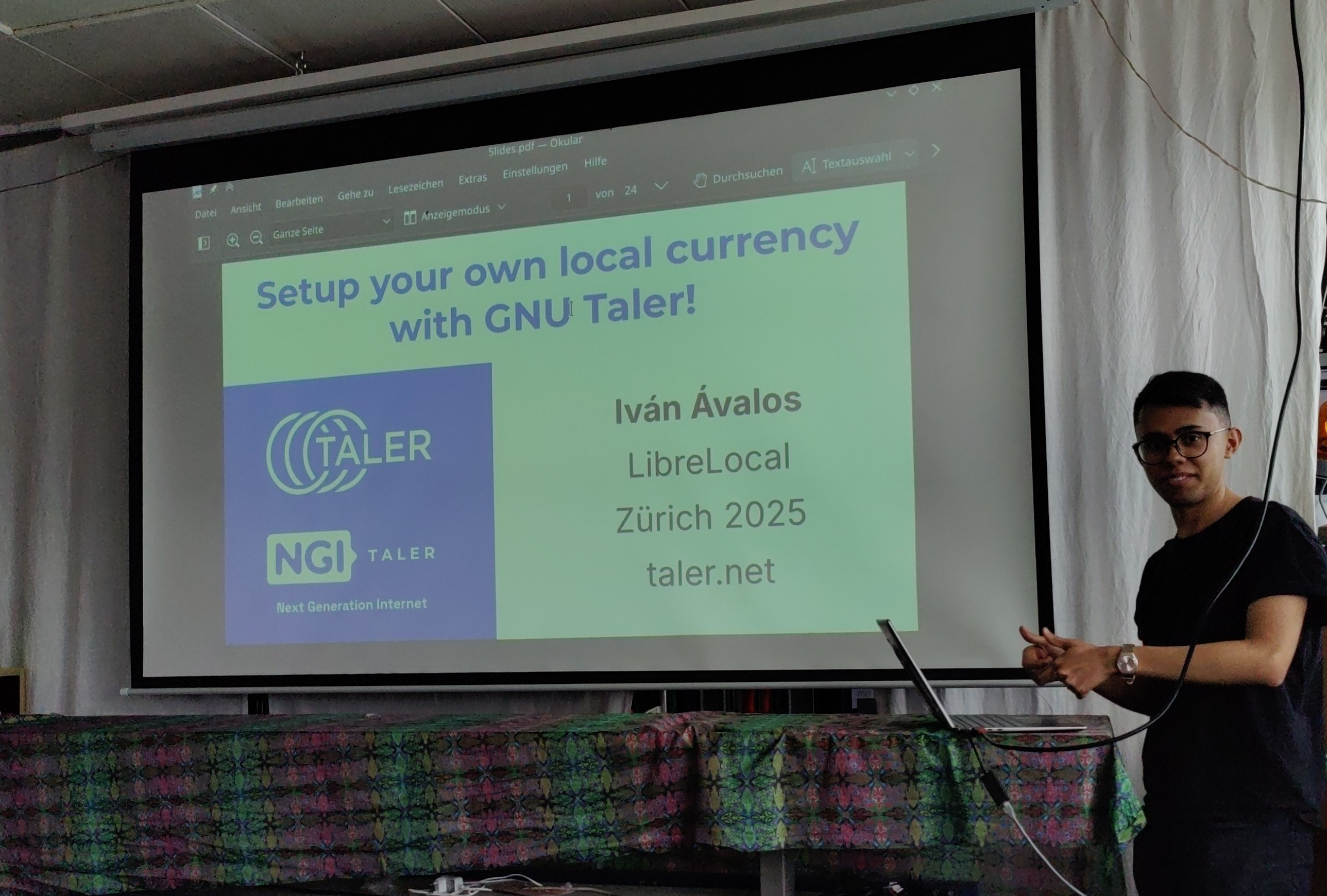 A slide deck cover page that reads 'Setup your local currency with GNU Taler, Iván Ávalos, LibreLocal, Zürich 2025, taler.net' with Iván Ávalos to the right of the image