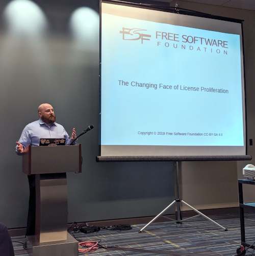 FSF licensing and compliance manager Donald Robertson, III stands at a podium next to a screen showing a slideshow at the FSF Continuing Legal Education seminar in Raleigh, North Carolina, in October 2019.