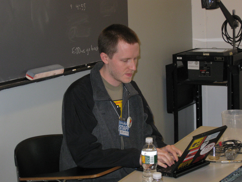 An image of John Sullivan behind a computer